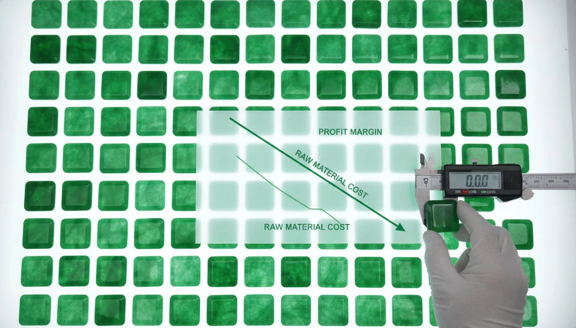 Dozens of neatly arranged square jade tiles are displayed on an illuminated tabletop.